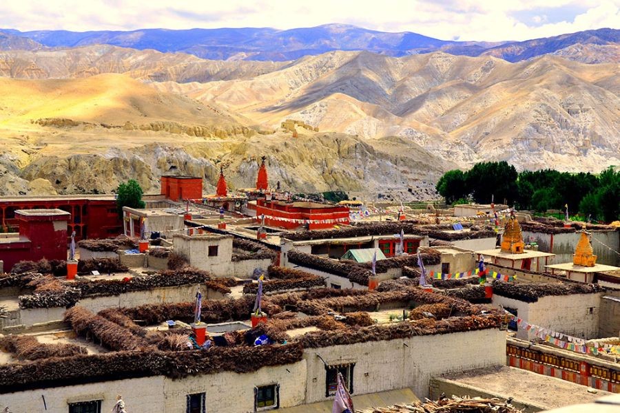 Traditional Dolpo village with flat-roofed stone houses against dramatic mountain backdrop